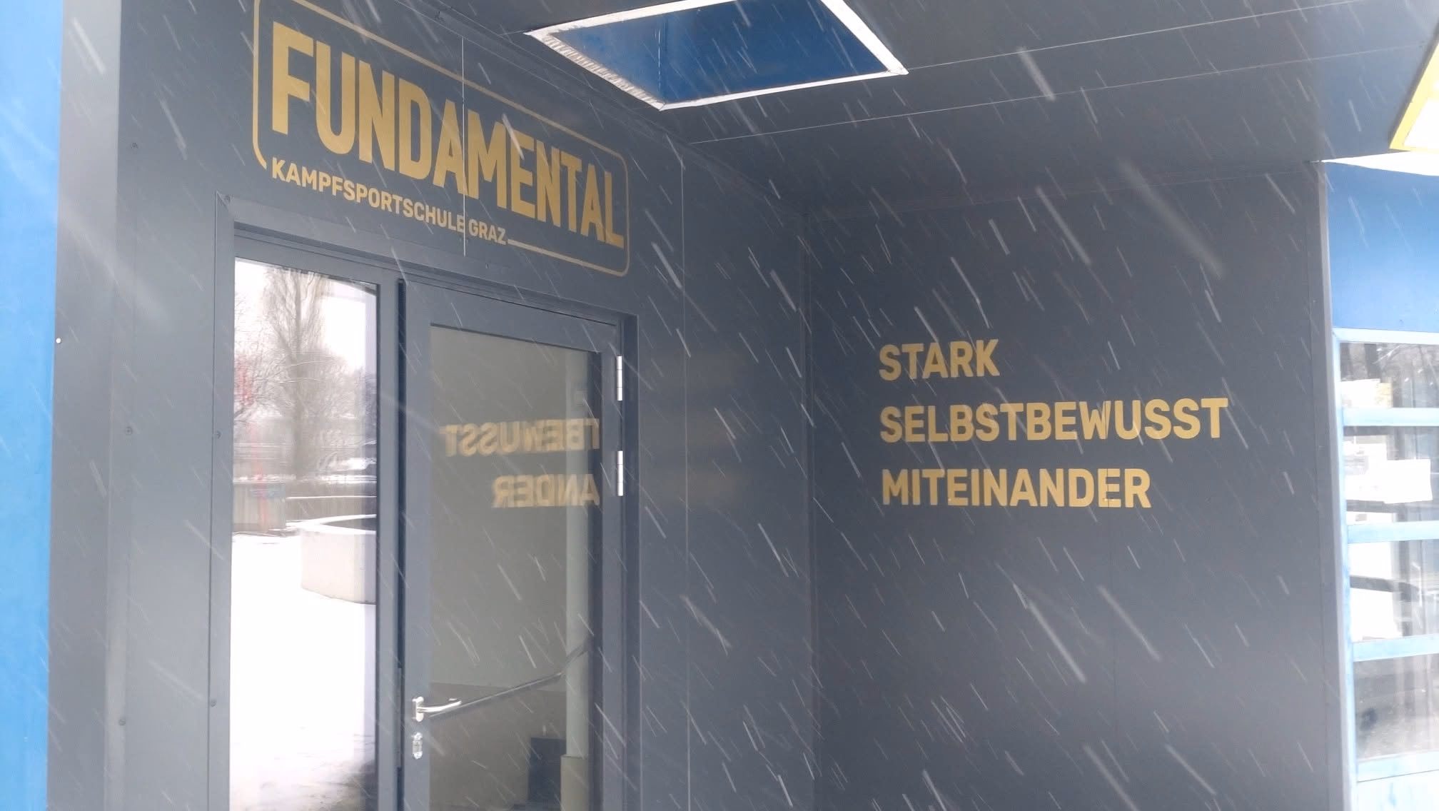 Fundamental – goldene Fassadenbeschriftung im Schnee